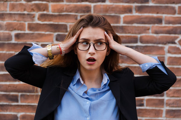 Frustrated business woman holding his hands to her head in frustration